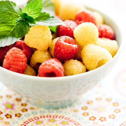 Assorted berries: Golden and red raspberries in a bowl.