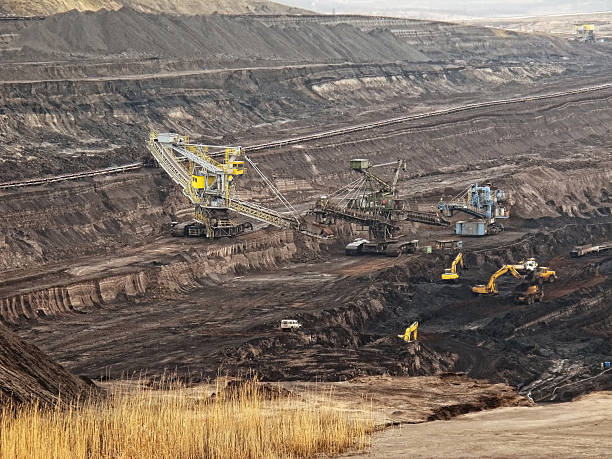 istock open Strip Coal mine with large excavators at conveyor belt 155286530