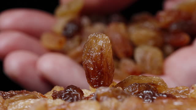 I pour a handful of raisins into my palm while the raisins are spinning on the table. Slow motion.