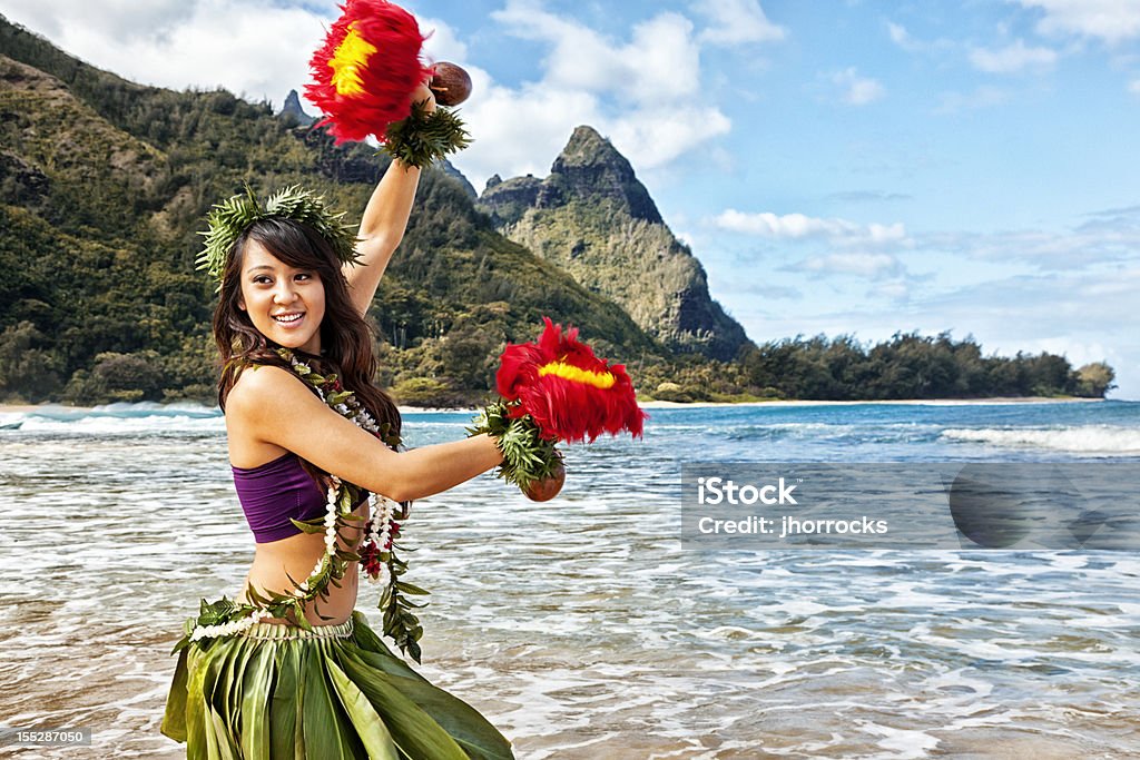 Hawaiian Hula Dancer on Beach with Red Feather Shakers Attractive young hula dancer, dancing on a Hawaiian beach with red feathered shakers ('Uli 'Uli). Mount Makana ('Bali Hai') in the background. Big Island - Hawaii Islands Stock Photo