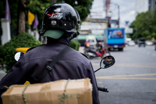 A motorcycle drivers observes themselves in the rearview mirror while waiting ata. stoplight  near the Parliament on July 18, 2023. People gather to demonstrate outside of the Thai Parliament, also known as the National Assembly of Thailand, to demand Wan Muhamad Noor Matha, the House Speaker, and the 250 military-appointed senators to listen to who they want to be elected the next Prime Minister in the second-round bicameral vote to be held on July 19, 2023.