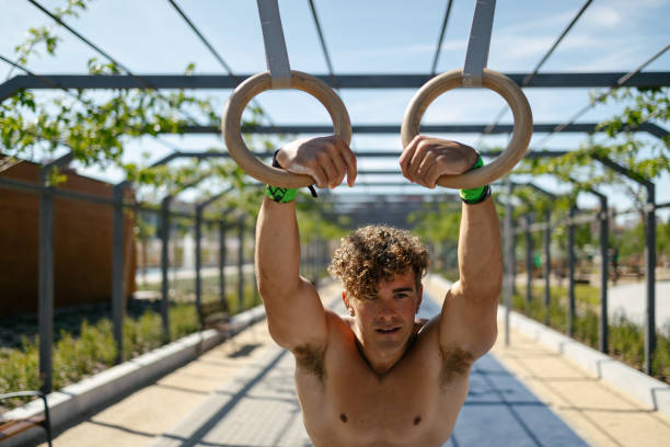 istock Strong young sportsman exercising with rings 1552872727