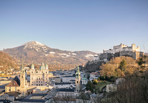 High angle view over the Austrian city of Salzburg, with the Hohensalzburg Fortress to the right, and snow on the Gaisberg Mountain to the left of the picture.
