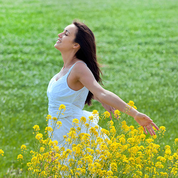 istock young woman enjoying the spring in meadow 155287423