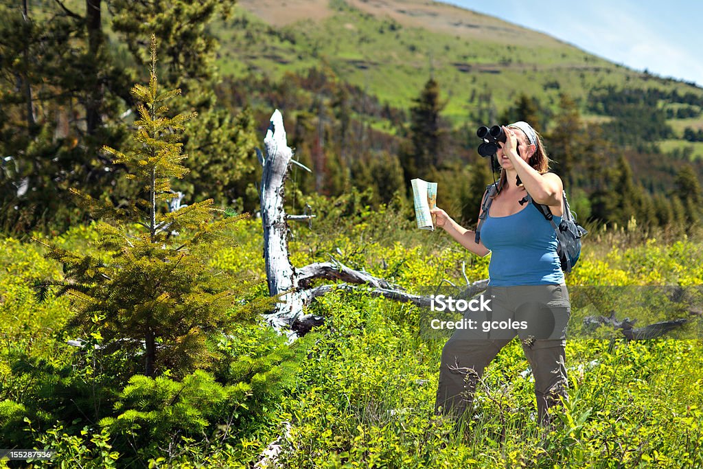 Mujer con mapa con binoculares - Foto de stock de 20-24 años libre de derechos
