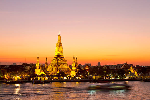 Famous Wat Arun temple in Bangkok at dusk Wat Arun, also called the Temple of Dawn in Bangkok along the Chao Praya river at sunset (pure light/no filter). Copy space in the sky. wat arun stock pictures, royalty-free photos & images