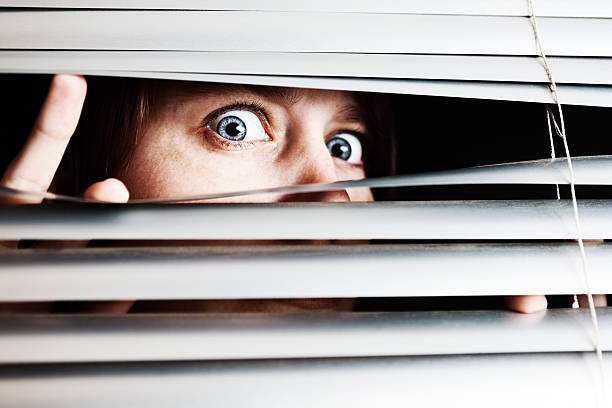 istock Young woman recoils scared by what she sees through blind 155287758