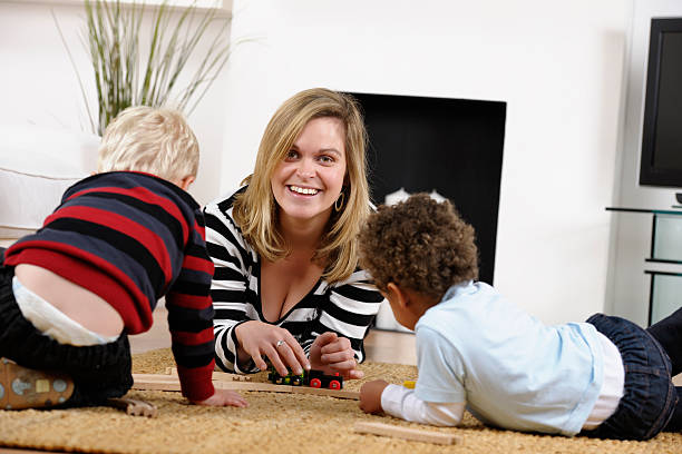 istock Mother/ Carer/ Childminder And Toddlers Playing With Train Set 155287798