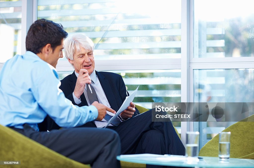 Geschäftsleute, die über einige Dokumente - Lizenzfrei Alter Erwachsener Stock-Foto