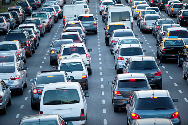 autos in der rush hour mit verkehr in der abenddämmerung - autobahn stau stock-fotos und bilder