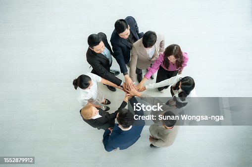 istock Top view of group of business people joining hands together in office to empower each other 1552879912