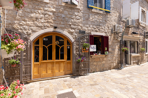 Budva, Montenegro - June 28, 2023: A picturesque narrow street with stone houses typical for Mediterranean countries. It is the first alley past the Main Gate to the city