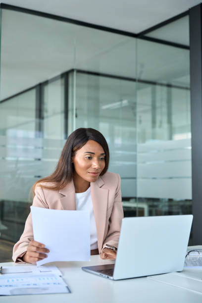 istock Busy business woman manager checking document using laptop in office, vertical. 1552918842