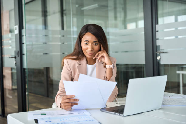 istock Serious business woman account manager checking documents working in office. 1552918844