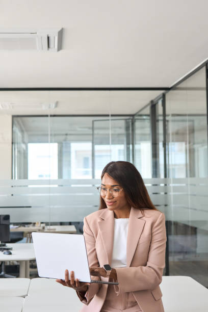 istock Young business woman working in office holding using laptop computer. 1552919423