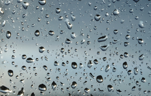 Rain drops on window glass outside texture with nature background