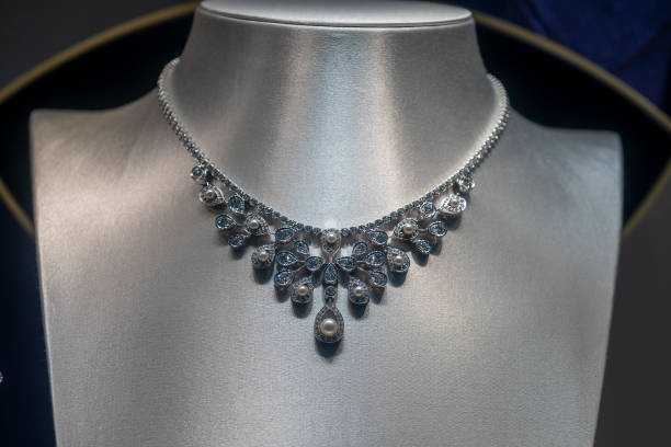 マネキンのネックスタンドディスプレイに白い金色のフレームに貴石が付いた真珠の高級ネックレス