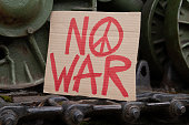 No War placard with peace sign on military army tank in protest against war.