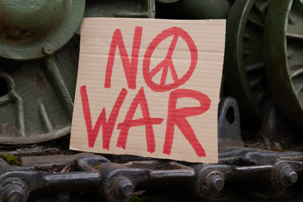 No War placard with peace sign on military army tank in protest against war. No War placard with peace sign on army tank caterpillar continuous track wheels. Military armored tracked fighting vehicle with anti-war banner in protest against war. peace demonstration stock pictures, royalty-free photos & images