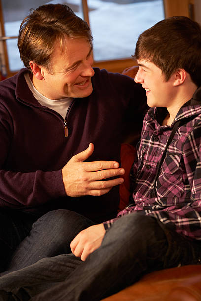 istock Portrait Of Father And Son Relaxing On Sofa Together 155295893