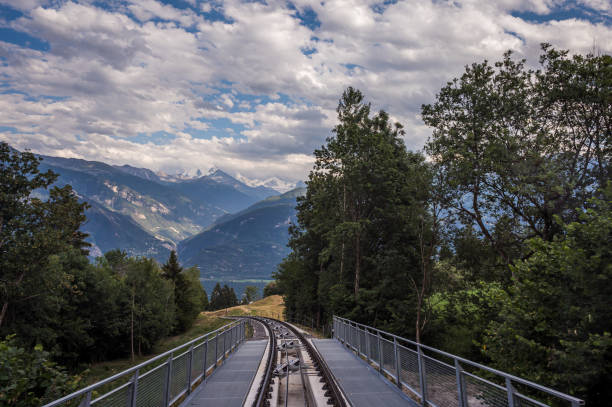 High angle view over mountain, Sierre city and funicular trail. Crans Montana, Valais Canton, Switzerland.