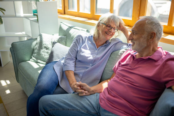 istock Senior couple talking and holding hands at home 1552978634