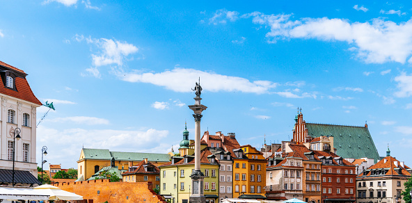 View of the buildings surrounding Plac Zamkowy, also known as Castle Square, in Warsaw's Old Town Centre. The frame showcases the diverse architectural styles and structures that define the area. On the left side of the image, Kolumna Zygmunta III Wazy, or Sigismund's Column, stands prominently. The focus is solely on the buildings, without any people or roads visible.