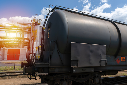 Railroad tank car near oil refinery. Railway train cargo wagon to transport liquid and gaseous commodities. Industrial zone equipment, rail freight transport.