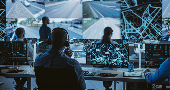 Diverse Team of Specialists Analyze Surveillance Feeds, Monitor Targets on a GPS City Map, Ensure Efficient Traffic Operations. Intensive Work in a Monitoring Room with Big Data Analytics Engineers