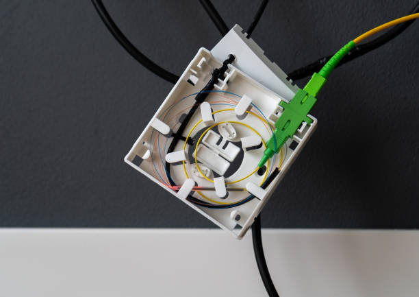 installation of fiber optic cable in a box on the wall at home. high speed internet network connection. - splice imagens e fotografias de stock