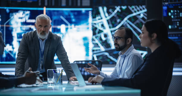 istock Team of Surveillance Experts Having a Discussion During a Meeting in an Advanced Research Center. Diverse Group of Professionals Monitoring an Active Operation with Satellite Tracking Technology 1553007826