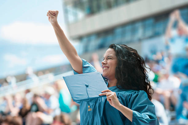 femmina laureati alzando il pugno - cheering arms raised women university foto e immagini stock