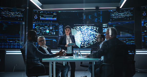 Chief Software Engineer Conducting a Quality Assessment Meeting With His Artificial Intelligence Design Team. Group of Developers Discussing Possible Development of a New Advanced Neural Network