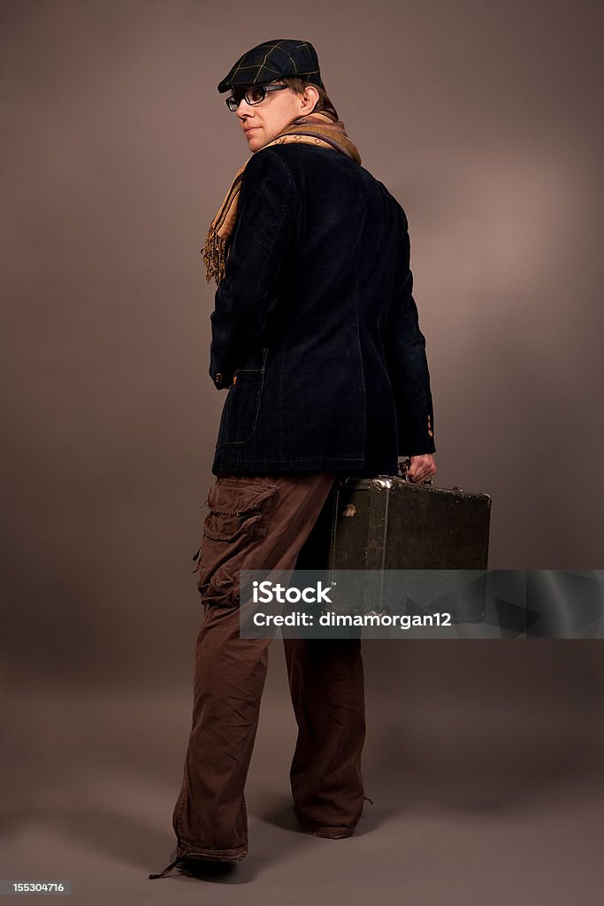 Uomo con valigetta guardando indietro - Foto stock royalty-free di Abbigliamento