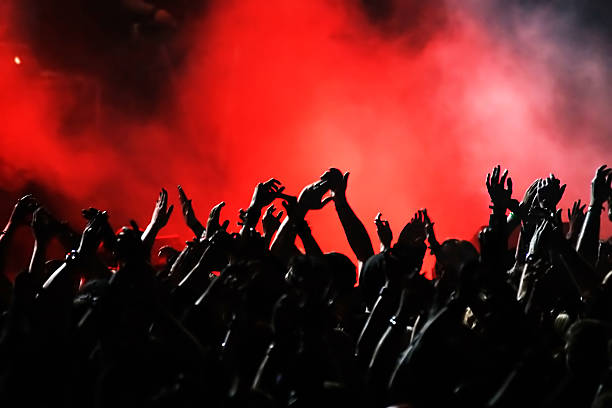 istock A crowd raising their arms and cheering at a concert 155304791