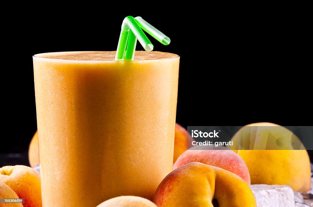 Peach smoothie with green straws and fresh peaches A glass of freshly made peach smoothie Dessert - Sweet Food Stock Photo