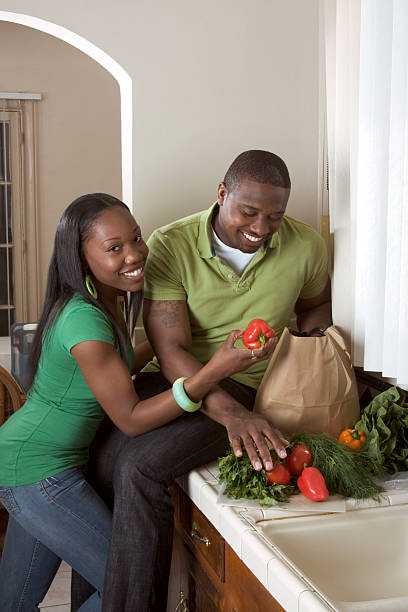 istock Young ethnic couple on kitchen sorting groceries 155306642