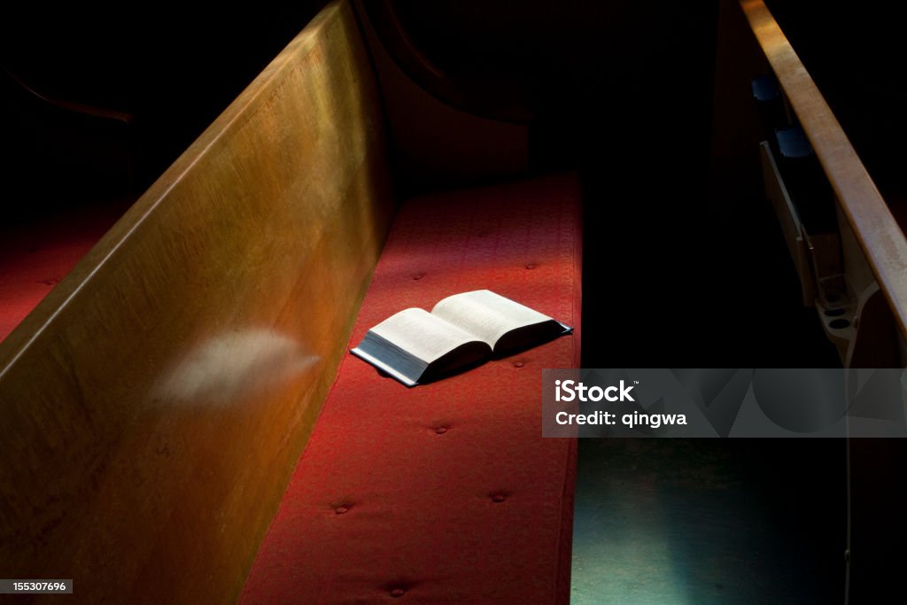 Ouvert Bible allongé sur l'église Pew en étroite bande de soleil - Photo de Banc d'église libre de droits