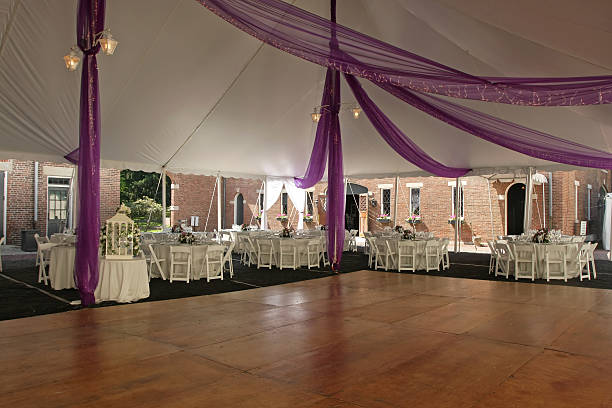 Empty wooden dance floor inside wedding marquee with tables stock photo
