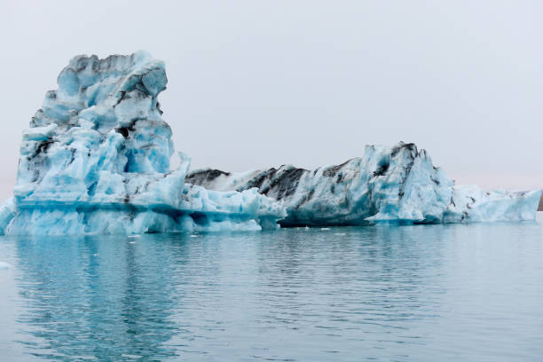 un iceberg en islandia. un iceberg que desemboca en la laguna de jokulsarlon, separado del frente del glaciar. - natural disaster glacier iceberg melting fotografías e imágenes de stock