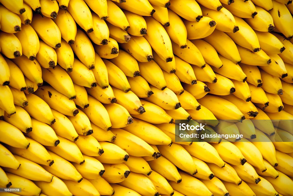 Huge stack of Bananas Full frame closeup of wall of bananas at fruit vendor. Great for backgrounds, backdrops, or puzzle. Banana Stock Photo