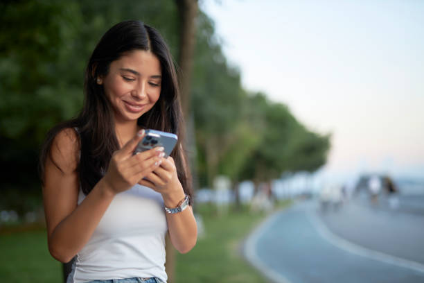 istock young brunette at seaside park texting lover 1553128703