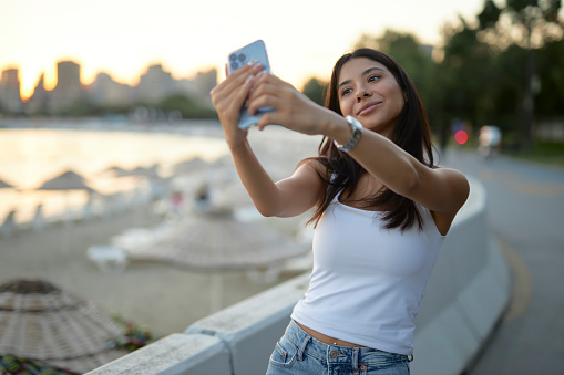 confident young girl taking selfies at a park in istanbul enjoying nature and seaside with sun