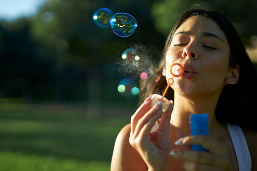 young girl in white shirt using bubble wand for fun