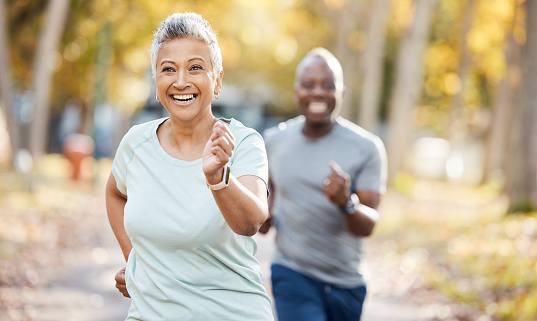 Health, race and running with old couple in park for fitness, workout and exercise. Wellness, retirement and happy with senior black man and woman training in nature for motivation, sports and cardio