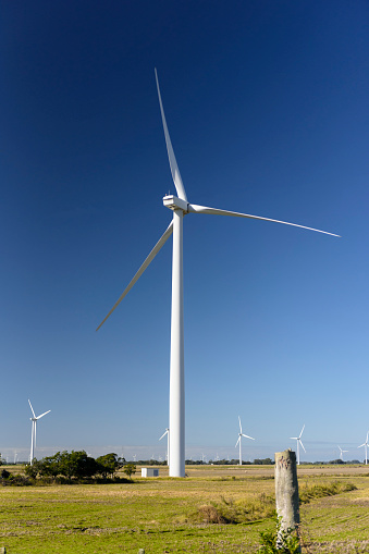 Wind turbine in operation. Close-up aerial view of a sunny European landscape.