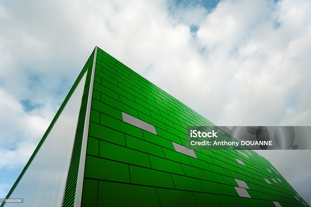 Modern building Modern architecture. Wide angle view of a green front under cloudy sky. Abstract Stock Photo