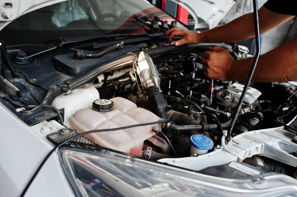 istock Car repair and maintenance theme. Mechanic in uniform working in auto service, checking engine. 1553162864