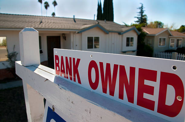 Bank Owned Sale A foreclosed home shows a bank owned for sale sign. foreclosure photos stock pictures, royalty-free photos & images