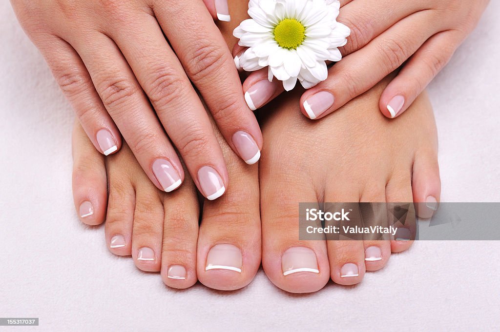 Skincare of a beauty female feet Skincare of a beauty female feet with camomile's flower Manicure Stock Photo